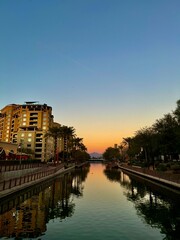 sunset on a perfectly clear night reflecting over the river lined with palm trees
