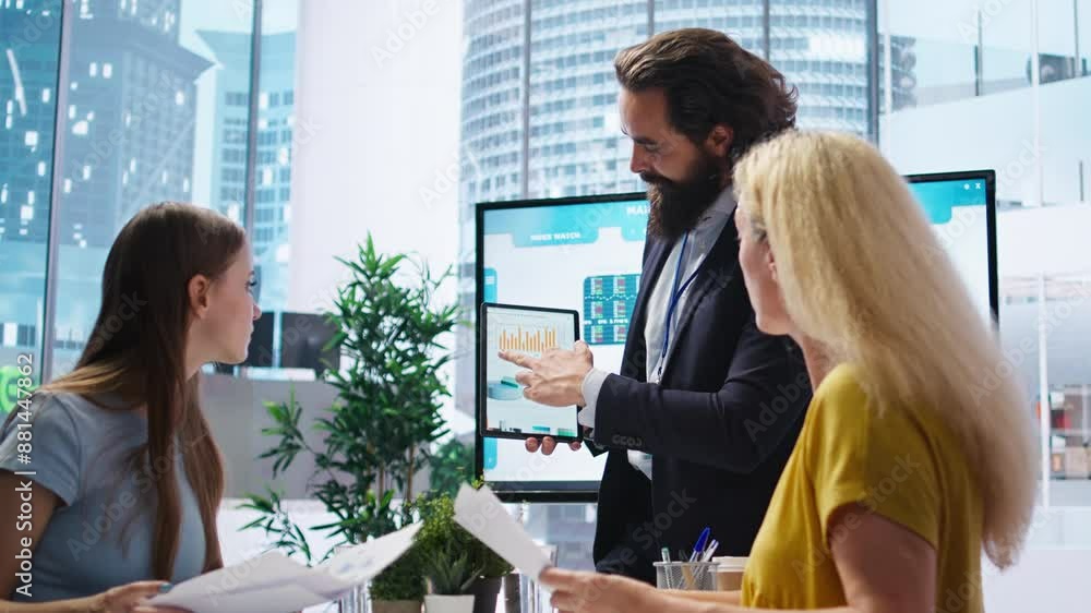 Poster financial adviser presents market analytics to clients using large display and tablet device, teachi
