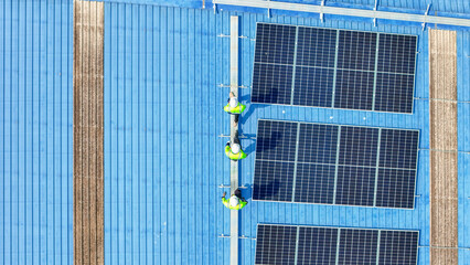 engineer man inspects construction of solar cell panel or photovoltaic cell by electronic device. Industrial Renewable energy of green power. factory worker working on tower roof.