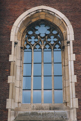 Elongated vintage vertical window on the facade of the building. Baroque and Gothic architecture. Church of St. Olga and Elizabeth. Lviv, Ukraine.