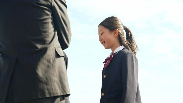 青空の下で会話する親子