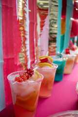 Colorful close-up of a row of festive drinks in plastic cups