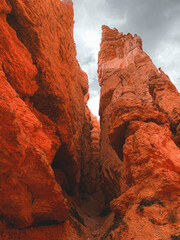 the iconic hoodoos of Bryce Canyon, towering red rock spires set against a vibrant blue sky with scattered clouds. The dramatic formations highlight the unique geological features and natural beauty o