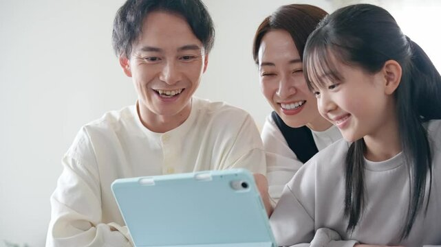 みんなでタブレットを見る家族