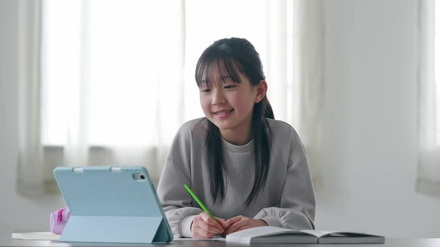 タブレットPCを見ながら勉強する女の子