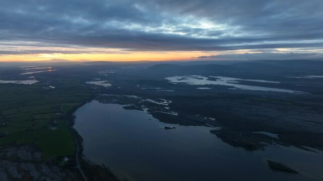 Lough Bunny, County Clare, Ireland, November 2023. Drone panoramic overview of lake in burren during blue hour as last light of sunset recedes.