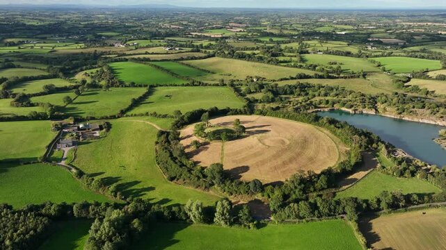 The Navan Fort, County Armagh, Northern Ireland, September 2022. Drone high angle orbit with slow push in to circular mound pattern on side of cultural heritage site.