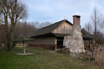 View of a wooden building and a large outdoor oven on the territory of the park of culture and recreation of the agrotouristic complex 