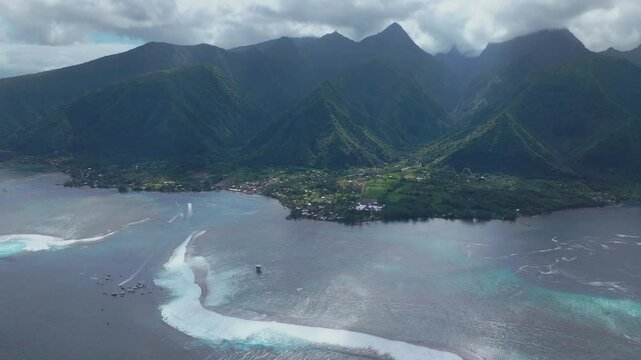 Coastal Teahupoo Tahiti aerial drone view perspective French Polynesia coral reef surf break waves Pacific Ocean channel boats cloudy sunny new judge tower Point Faremahora Pass Havae backward pan