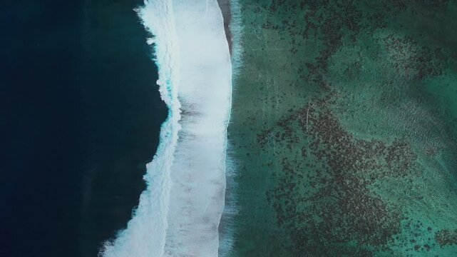 Waves crashing on colorful aqua turquoise shallow coral reef Teahupoo Tahiti aerial drone birds eye view perspective French Polynesia surf wave Pacific Ocean Channel Point Faremahora Pass Havae static