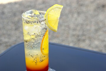 cold summer drink with slice of lemon and basil seed in an outdoor cafe