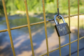 Padlock on a bridge yellow fence, soft focus close up