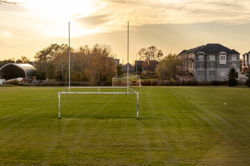 Golden-hour lighting over serene soccer field - goalposts standing tall - suburban houses, trees backdrop. Taken in Toronto, Canada. © Jacob Tian