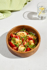 Freshly Fried Halloumi with Tomatoes and Arugula Salad in Wooden Bowl