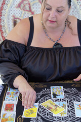 Fototapeta premium gypsy fortune teller dressed in black casting tarot cards