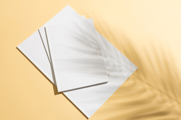 A stack of blank white paper on a yellow background with copy space