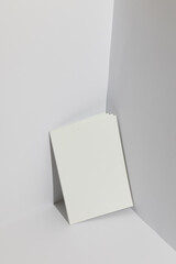 A blank white book stands in a corner, with copy space