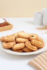 Danish butter cookies on a white plate on a white table. Perfect for recipe, design element, article, or any commercial purposes.