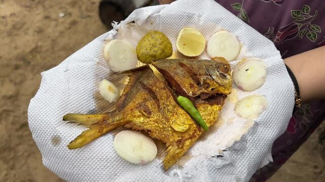 Fried white pomfret served in the beach of Digha, Bengal with onion and lime