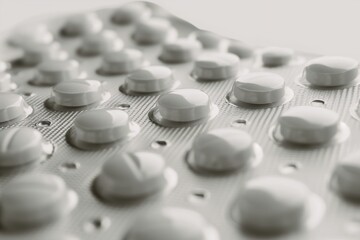 Close-up of White Pills in Blister Pack on Light Background