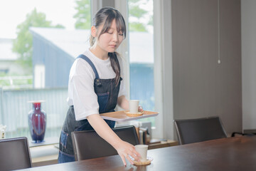 飲み物を出すを若い女性