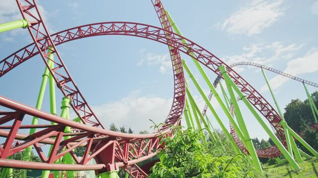 Roller coaster Ride against blue sky. Roller coaster in the amusement park. Cheerful entertainments in park of attractions