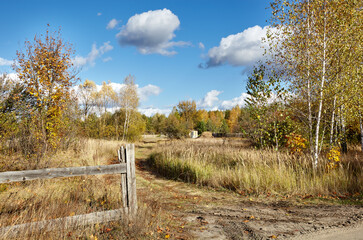 Obraz premium Old wooden fence against a sky on a sunny day. Beautiful summer or autumn rural landscape