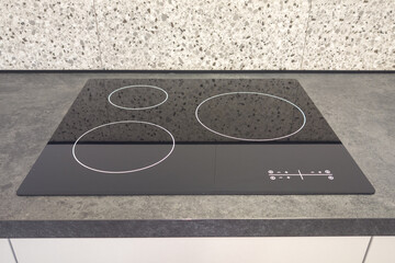 Modern kitchen interior with black induction electric hob stove cooker with marble countertop
