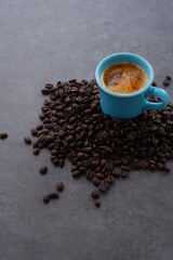 エスプレッソに牛乳をたっぷり入れたコーヒー、カフェ・ラッテと、深煎りしたコーヒー豆
