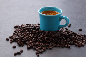 エスプレッソに牛乳をたっぷり入れたコーヒー、カフェ・ラッテと、深煎りしたコーヒー豆
