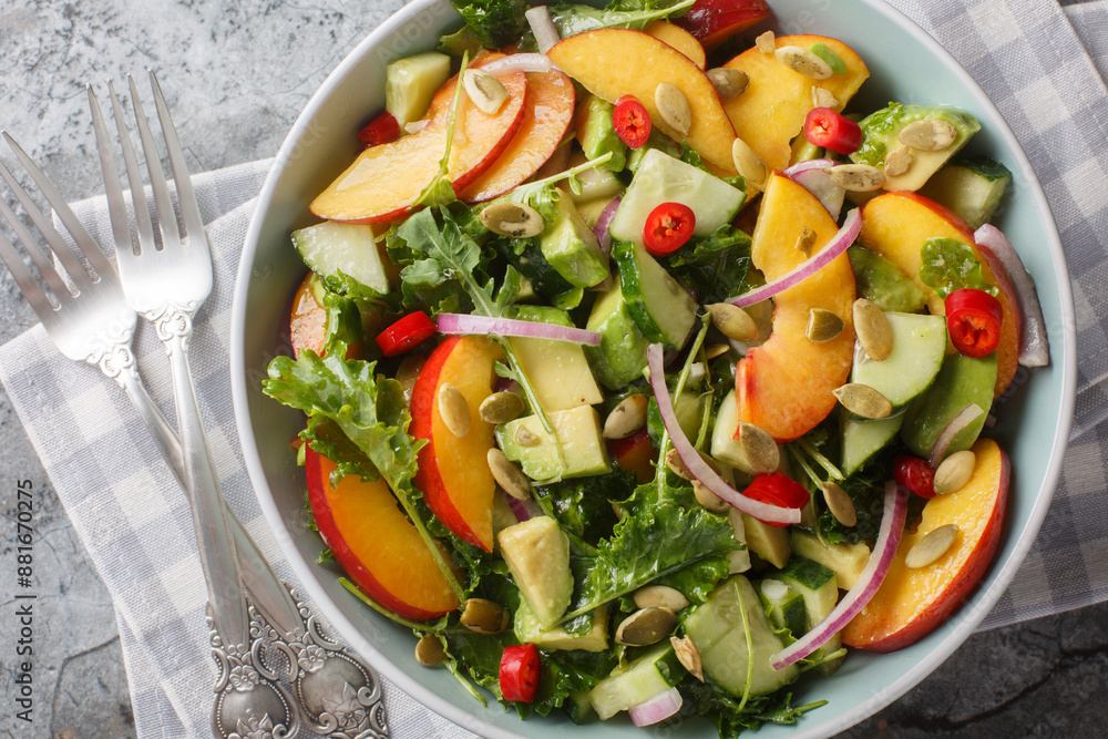 Wall mural vegan vitamin salad with peach, avocado, cucumber, red onion, chili, arugula, spinach and pumpkin se