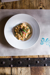 Gourmet dish of risotto with greens and garnish in a white bowl.