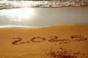 Sea sunrise of first new day for 2025 year text on beach sand