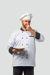 Indian asian male Chef in uniform holding rotten smelly dish, isolated white background
