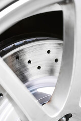 Drilled performance disc brake rotor mounted on a car, symbolizing automotive technology, safety,...