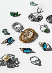 Different jewelry on white background. Pattern. Ring, earrings, brooch, diamonds, pearls. Top view.