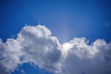 White clouds cover the sun against a blue sky.