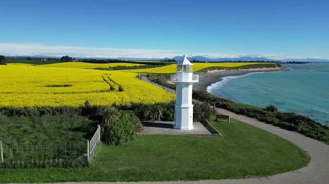 A drone scene in New Zealand (Aotearoa) featuring Tuhawaiki Point (Jack's) Lighthouse by the sea