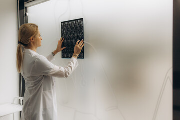 Female doctor checking anatomy and physiology x-ray film of patient in the hospital. Doctor Scientist checking examining viral infection on X-ray film