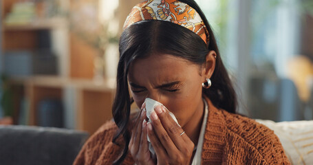 Indian woman, home and sick with blowing nose on illness, flu and sinus in living room. Female...