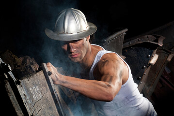 Miner pushing vagonetas iron ore within the mine