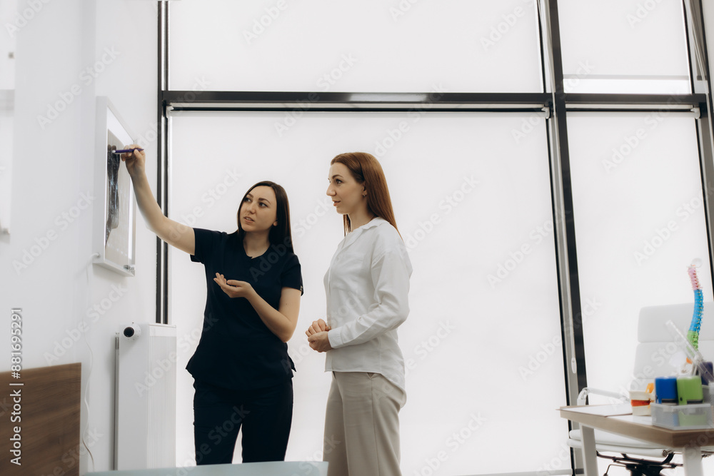 Wall mural medicine, healthcare and people concept - woman patient and doctor with spine x-ray scan meeting at 