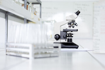 Laboratory microscope with test tubes on a workbench