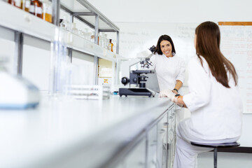 Two scientists working together in a bright laboratory.