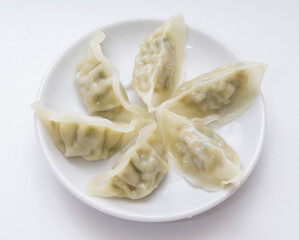 Close-up and top angle view of steamed dumplings on dish and white floor, South Korea
