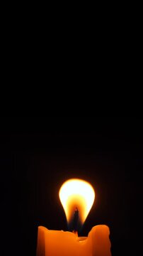 Burning Candle Wick Flame High Quality 4K Slow Motion Close-Up Macro Vertical Footage. Memorial Religious Romance Concept Dark Background.