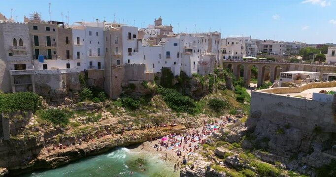 Crowd Of People On The Beautiful Beach Of Lama Monachile In Polignano a Mare, Bari, Puglia, Italy - Drone Shot