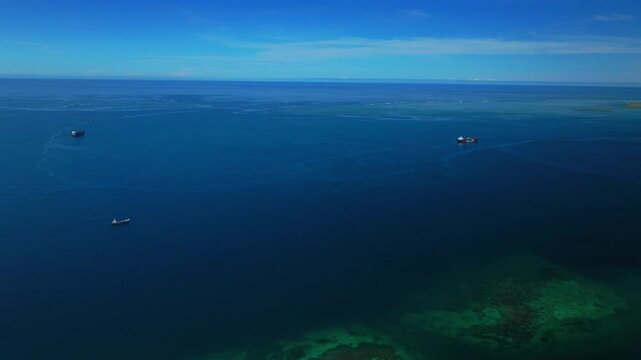 Ela Beach Port Moresby Papa Papua New Guinea Aerial drone cargo ship oil rig boat blue sky stunning sunny morning bay coastline hills PNG Capital City fishing wharf Harbor Idlers Bay forward pan up