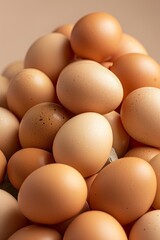 A close-up image showcases a large heap of fresh brown chicken eggs. Each egg displays a natural, speckled pattern, varying in shades of brown. The smooth, unblemished shells suggest the eggs are fres