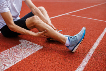 Athlete with leg cramp on running track